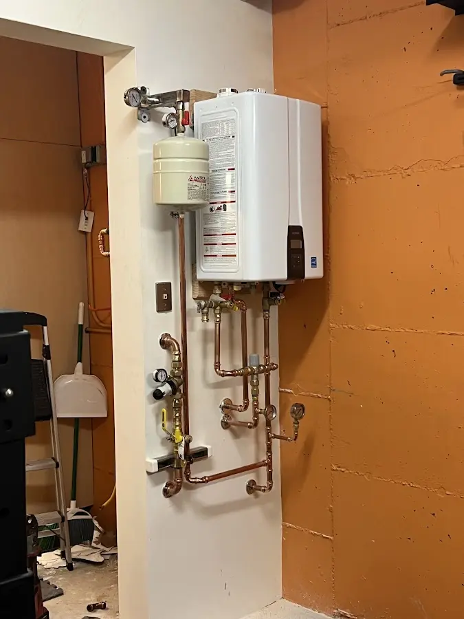 Plumbing technician inspecting water heater connections in Harlem